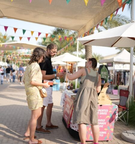 Visitors sampling homemade products at The Ripe Market – Academy Park Dubai artisan food stall.