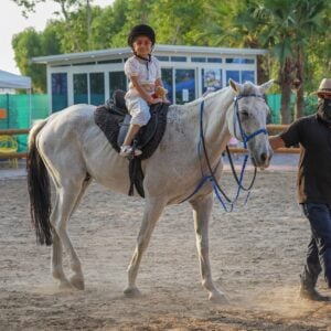 Kid enjoying riding a horse at The Ripe Market - Academy Park Dubai -
