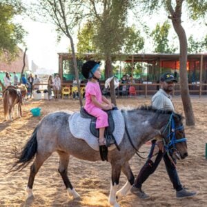 Child enjoying a pony ride at The Ripe Market – Academy Park Dubai.